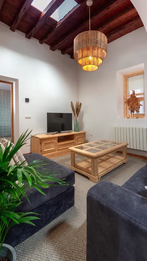 STILVISTA interior example: bright living room with timber ceiling and warm wood furniture